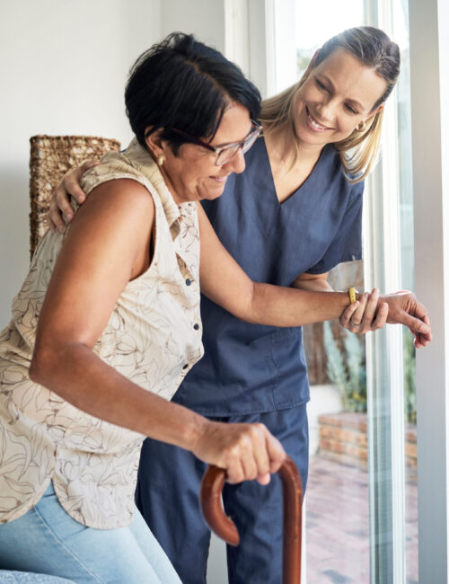 Happy woman, nurse and senior in elderly care, support or walking with stick at old age home. Medical caregiver or therapist helping patient or person with a disability in retirement or physiotherapy.